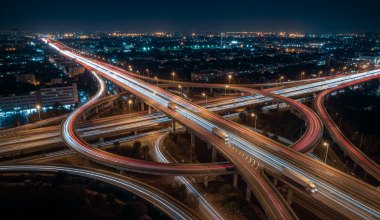 Highway interchange at night with light trails